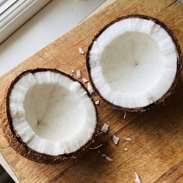 Coconut split in half on a wooden board